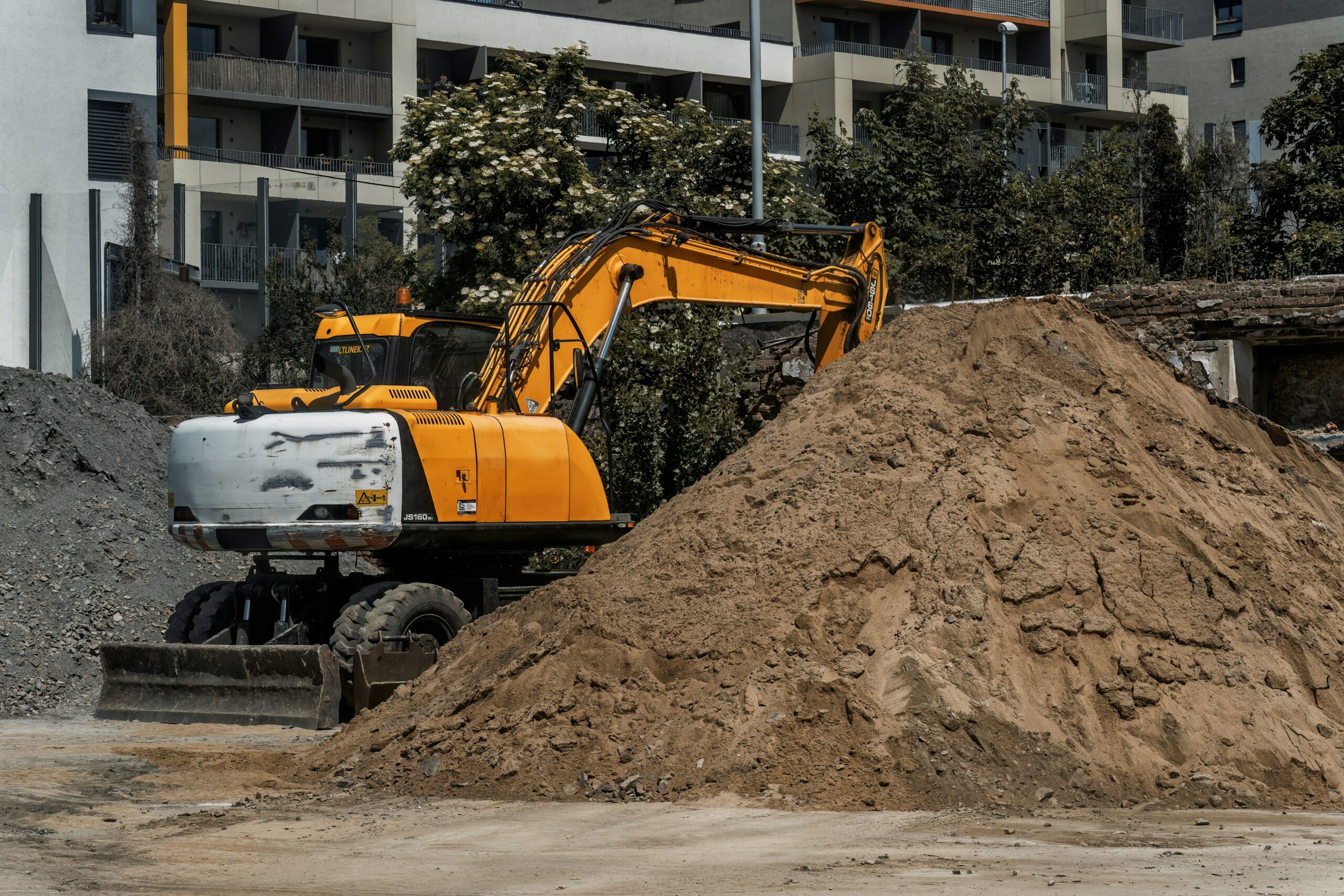 An image of an excavator doing excavation services in the dirt.